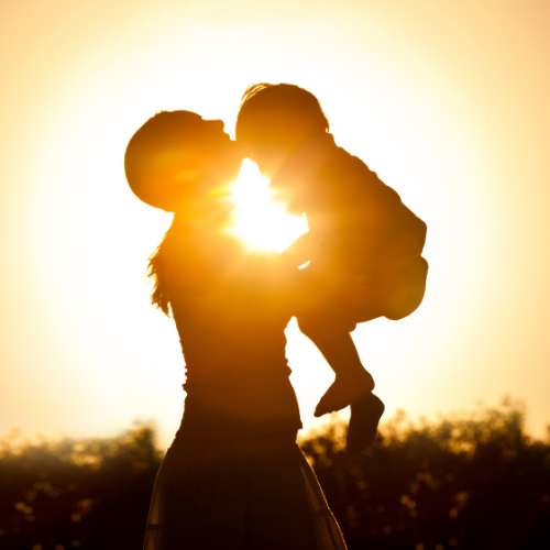 Madre abrazando a su hijo al atardecer
